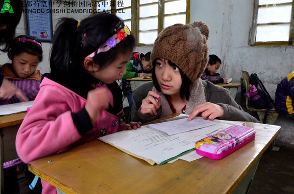 剑桥国际高中课程中心的学生为孩子们讲解习题