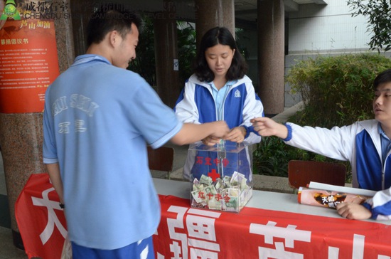 同学们将自己的一份心意投到捐款箱中